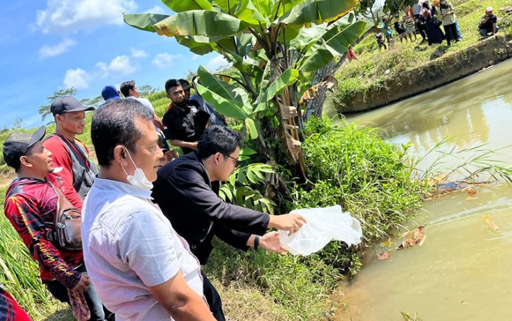 Ilyas Akbar Almadani saat menebar bibit ikan wader bersama warga di sungai Desa Gentungan, Mojogedang, Karanganyar, Minggu (3/7/2022).