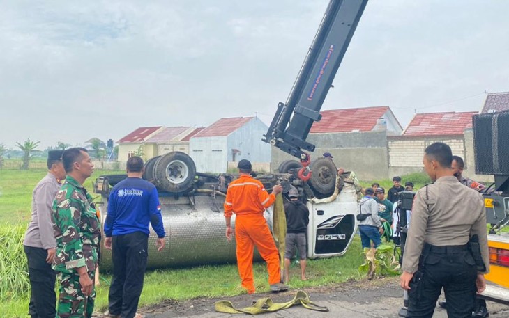 Upaya evakuasi truk tangki bermuatan air yang terperosok hingga terguling di areal persawahan di di Desa Karangmojo, Kecamatan Tasikmadu, Kabupaten Karanganyar, Senin (26/12/2022).