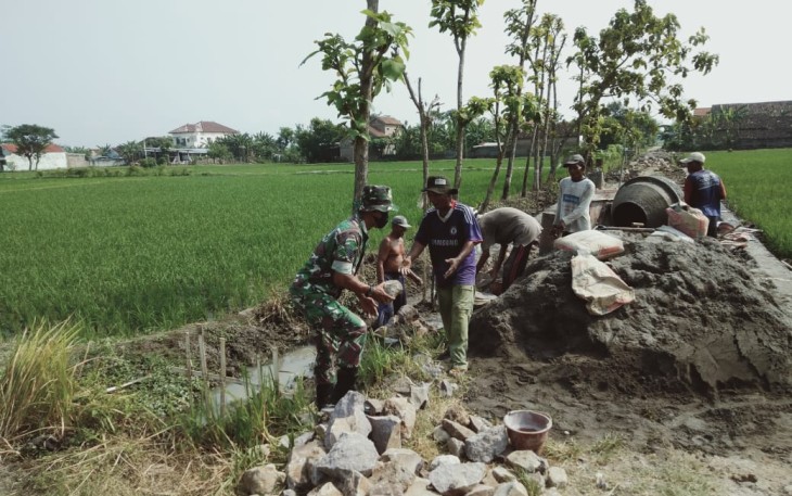 Babinsa Koramil Sawahan Bersama Warga saat Karya Bakti Bangun Talud