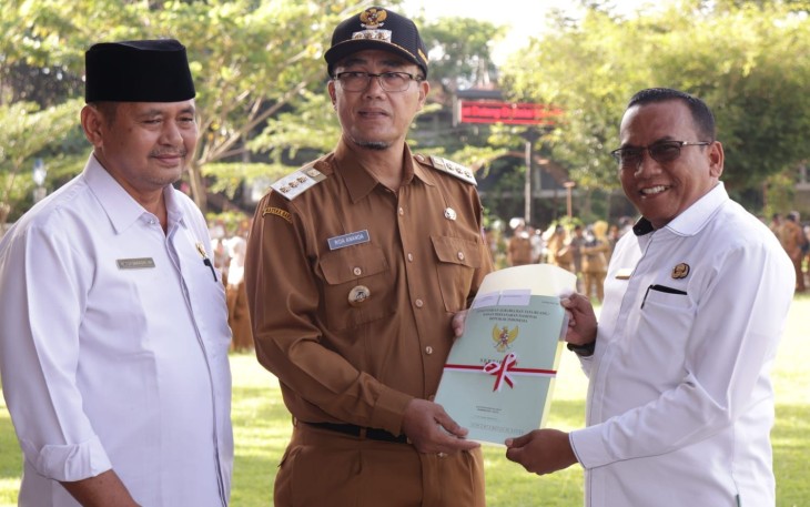 Pj.Wali Kota Payakumbuh, Rida Ananda menyerahkan sertifikat tanah secara simbolis kepada salah seorang penerima.