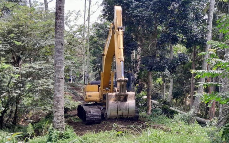 Menggunakan alat eksavator satgas TMMD Kodim 1310/Bitung buka lahan utk pembuatan jalan pertanian