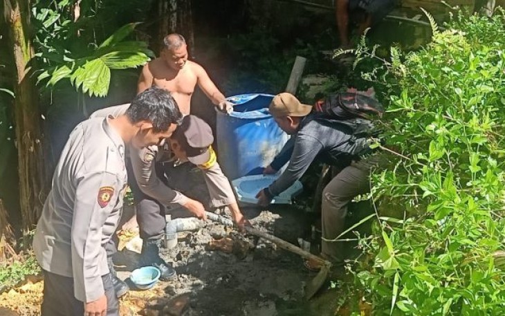 Bhabinkamtibmas Polsek Dolok, Bripka Heriandi Rambe, dan Brigadir Asullah Margolang, melaksanakan aksi gotong royong dengan warga di program stop buang air besar sembarangan (BABS)