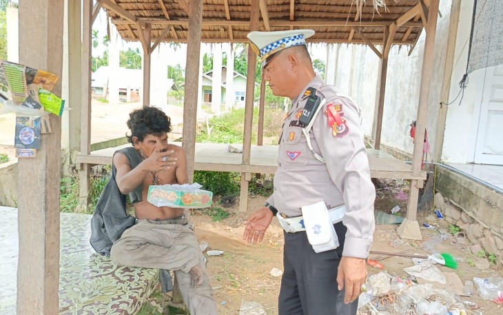 Kasat Lantas Iptu Eko Suhendro, S.H. membawa nasi kotak untuk dibagikan kepada masyarakat pengguna jalan yang melintas di depan Kantor Satlantas Polres Aceh Timur