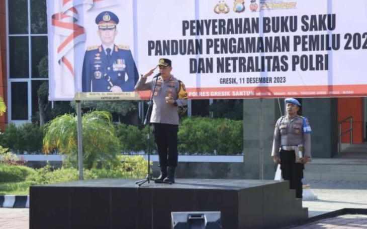 Kapolres Gresik AKBP Adhitya Panji Anom menyerahkan secara simbolis buku saku panduan pengamanan pemilu 2024 dan netralitas Polri kepada perwakilan personel di halaman Mapolres Gresik, Senin (11/12/2023)