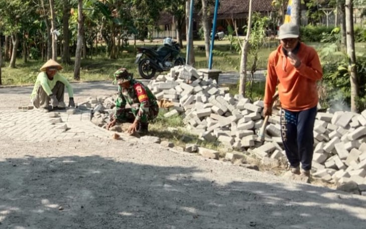 Babinsa saat Bantu Warga Pasang Paving