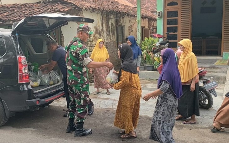 Serma Sukan Yusuf membagikan sayuran hasil panen dari kebun hidroponik yang berada di halaman Koramil kepada masyarakat.