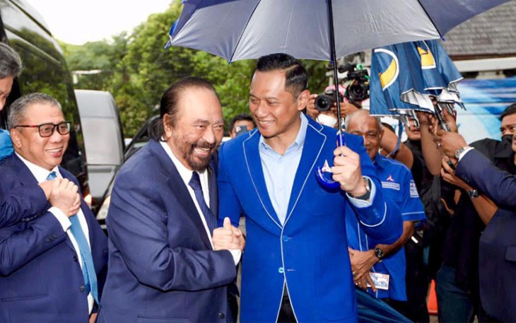 Ketua Umum NasDem, Surya Paloh saat disambut hangat dan dipayungi langsung oleh Ketua Umum Partai Demokrat, Agus Harimurti Yudhoyono (AHY) di depan kantor DPP Partai Demokrat, Rabu (22/2).