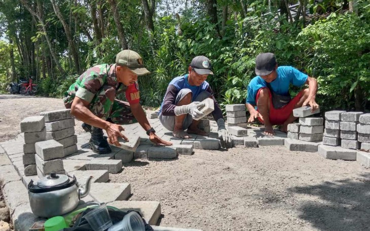 Pemasangan paving jalan desa binaan