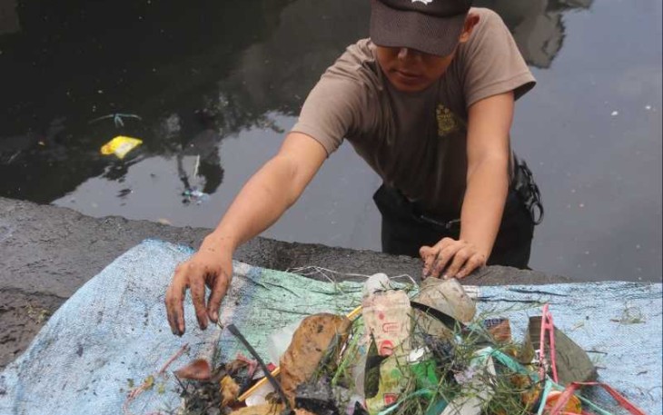 Personel Polda Sulsel Bersihkan Sampah di kanal pasar Terong, Kota Makassar, Kamis (13/7)