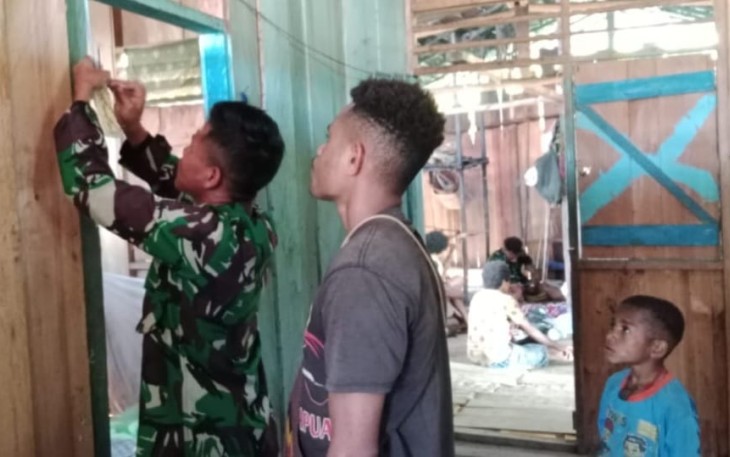 Satgas Yonif 143/TWEJ saat membantu warga menerangi rumahnya dengan memasang instalasi listrik di Kampung Tatakra, Distrik Web, Kab. Keerom, Papua, Senin (17/7/2023)