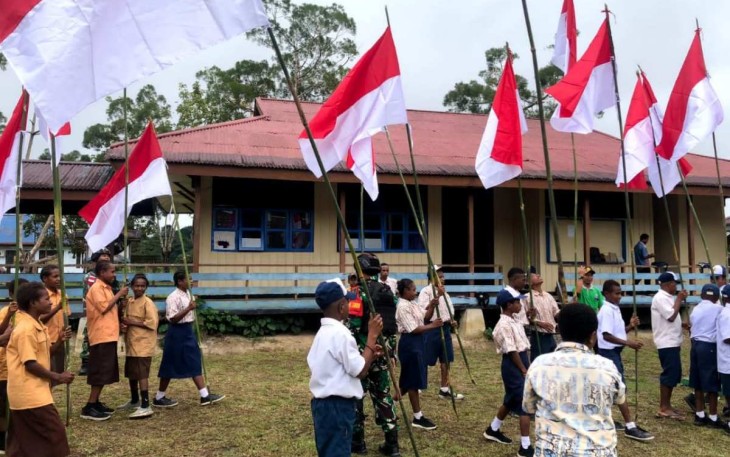 Kibarkan bendera merah putih bersama pelajar di jalan perbatasan, Kampung Web, Distrik Web, Kabupaten Keerom, Papua, Selasa (8/8)