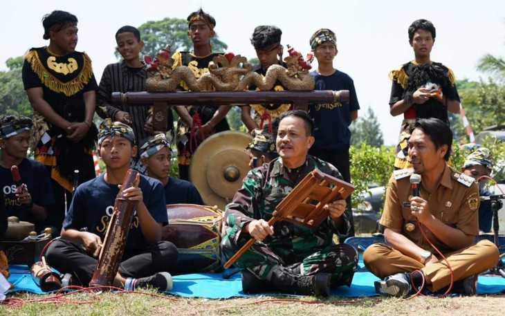 Irdam V Brawijaya Brigjen TNI Abdul Rachman saat mencoba alat musik Dongkrek disela penutupan TMMD Kodim 0803/Madiun, Kamis (10/8)