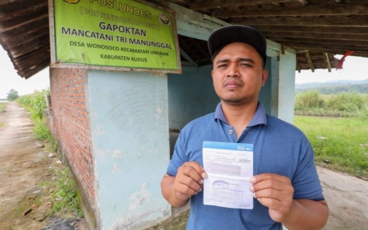 Suwarji petani di desa Wonosoco Undaan Kudus saat menerima klaim asuransi 