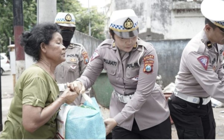 Personel Ditlantas Polda Jatim saat membagikan bingkisan