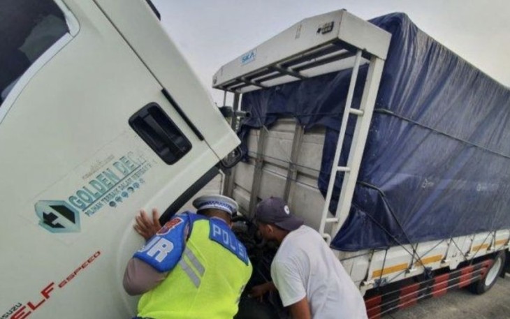 Anggota PJR Polda Jatim saat membantu perbaiki truk mogok di tol Jombang Mojokerto KM 683/B, Rabu (10/5)