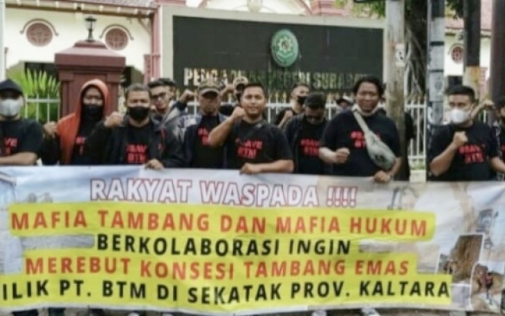 Aksi membentangkan spanduk di depan PN Surabaya, Minggu (14/5)