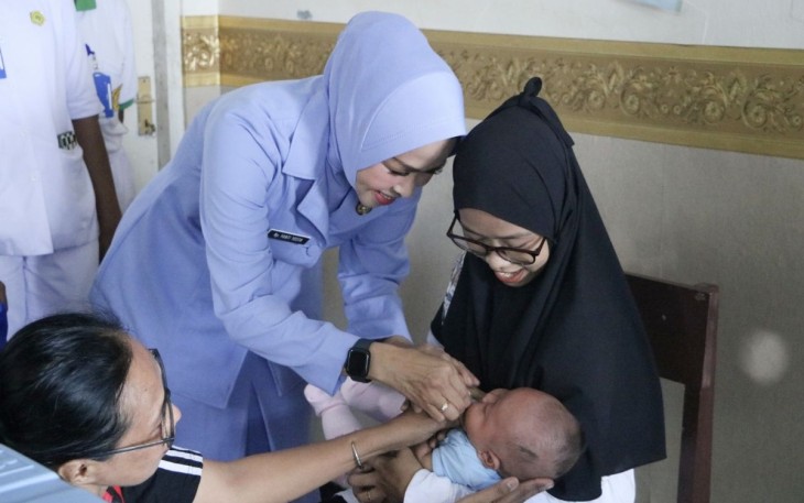 Ketua PIA AG Cabang 2/Daerah III Lanud Manuhua Ny Yanti Yostariza saat memberikan vaksin di posyandu balita, Sabtu (10/6)