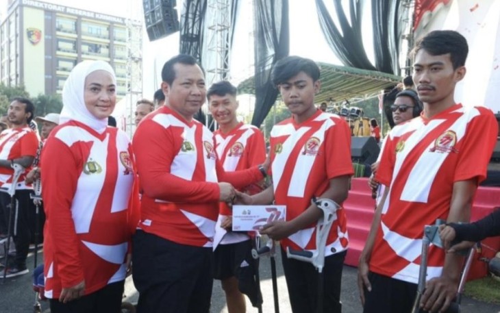 Kapolda Jatim Irjen Pol Toni Harmanto saat memberikan hadiah warga disabilitas binaan polisi RW Polda Jatim di Surabaya, Minggu (2/7)