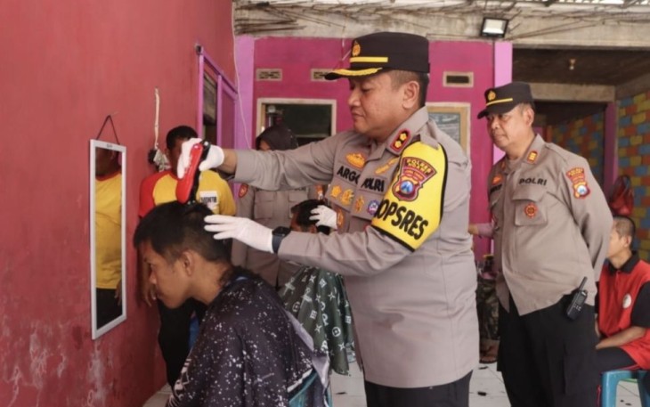 Kapolres Ngawi AKBP Argowiyono saat memotong rambut pria ODGJ, Selasa (19/9)