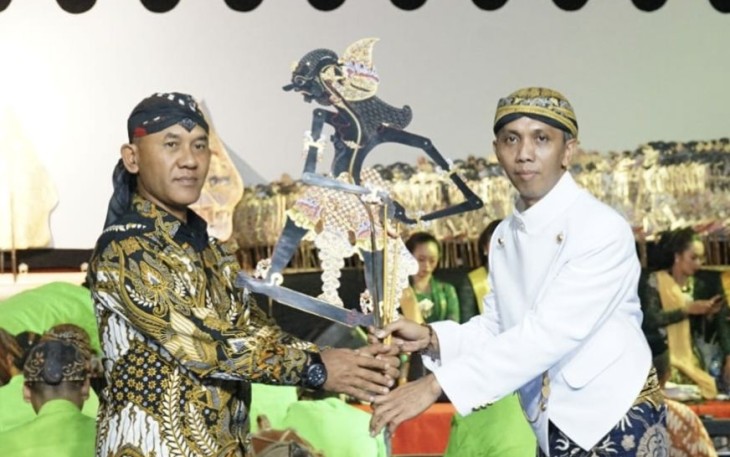 Danrem 081/DSJ Kolonel Inf H. Sugiyono menyerahkan wayang kulit dalam pagelaran di kediaman Panglima TNI Laksamana Yudo Margono, Jum'at (6/10)