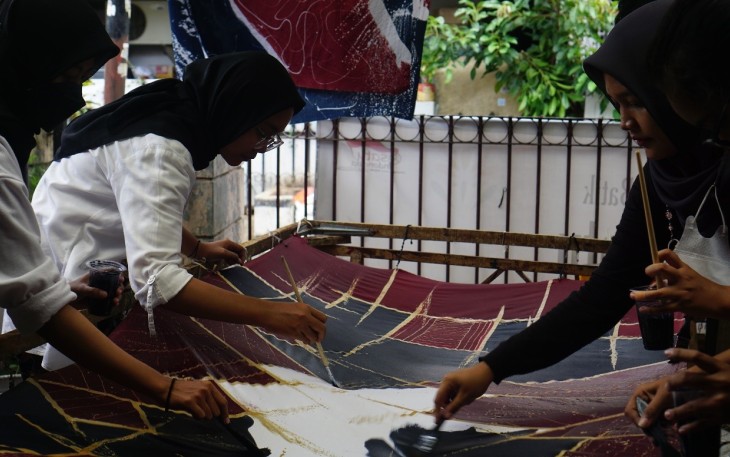 Mahasiswa KKN yang sedang melakukan proses cat pada kain. Foto:Lidia Pratama Febrian