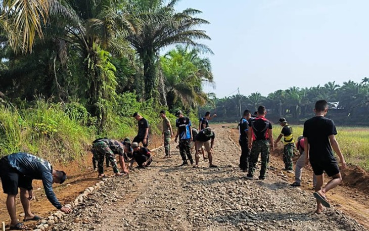 Satgas TMMD saat merapikan hasil pengerasan badan jalan