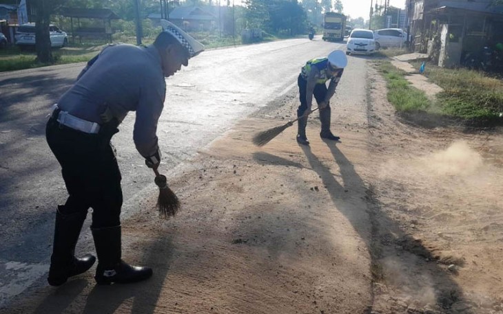 Anggota Satlantas Polres Aceh Timur Bersihkan Material Kerikil di Jalan