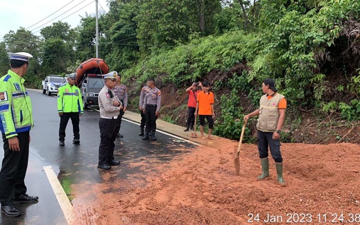 Polisi bersama Damkar dan BPBD Benteng Lakukan Pembersihan Badan Jalan Terkena Material Tanah Longsor.