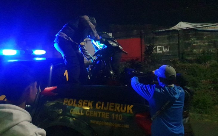Polisi saat evakuasi motor yang ditinggalkan, diduga milik pelaku.