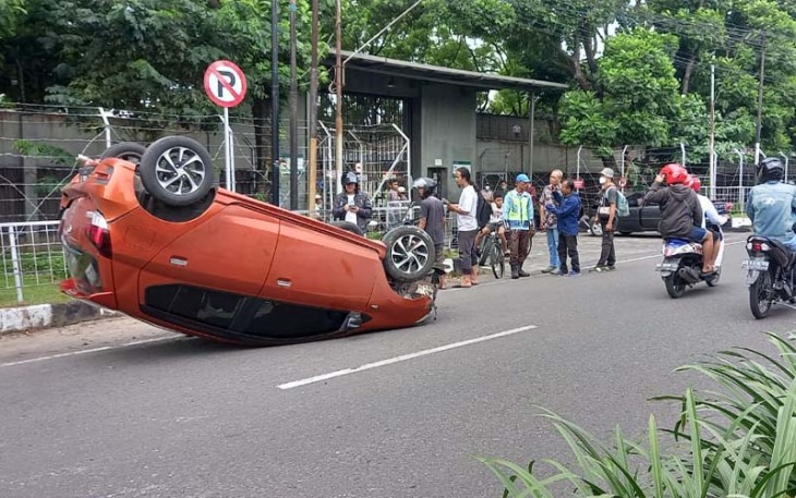 Daihatsu Ayla AD 1466 IP terguling setelah menghantam pembatas jalan akibat tertabrak dari belakang oleh Toyota Corrola AD 7729 DF, di depan PT Gunung Subur, Jaten, Karanganyar, Kamis (13/4/2023).