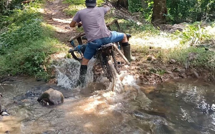 Dadang Nopian (32), salah satu warga Desa Kembang Ayun saat melintas di sungai kecil menuju kebunnya (sebelum sasaran Fisik TMMD ke-118 dimulai)