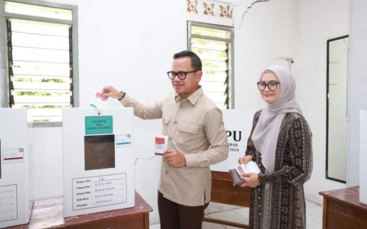 Wamendagri Bima Arya Sugiarto bersama istri saat menyoblos di TPS 16, Kelurahan Katulampa, Bogor, Rabu (27/11)