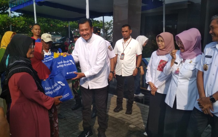 Direktur Utama Bank Daerah Karanganyar Haryono menyerahkan sembako murah kepada salah satu warga, dalam kegiatan GPM di halaman Kantor Kecamatan Kebakkramat, Jumat (5/5/2024)
