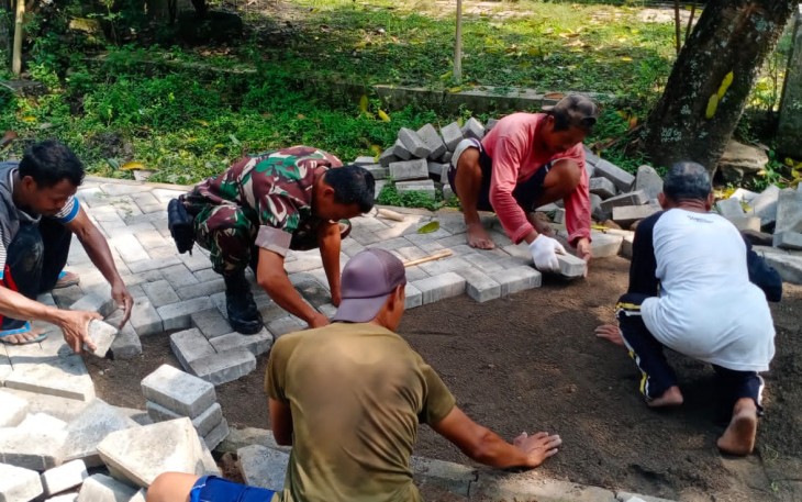 Babinsa Bantu Warga Pasang Paving Jalan Desa