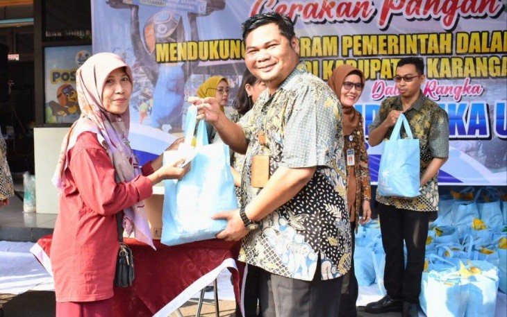 Dirut PUD Aneka Usaha, Samidi, menyerahkan paket sembako kepada salah satu warga dalam bazar pangan murah di halaman kantor PUD Aneka Usaha, Tasikmadu, Karanganyar, Selasa (26/3/2024)