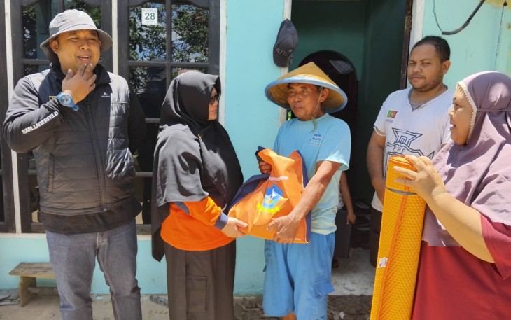 Kepala Dinas BPBD Kabupaten Bintan Romlah saat menyerahkan Bantuan pada Masyrakat tertimpa musibah  dampak hujan dan  angin kencang menghatam rumah warga