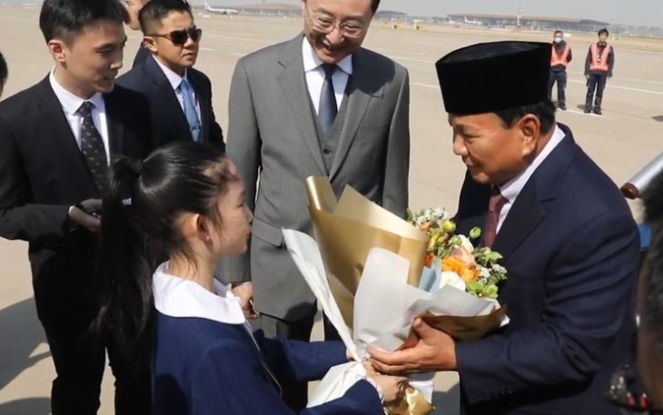 Menhan Prabowo Subianto menerima karangan bunga dari gadis kecil saat tiba di Beijing