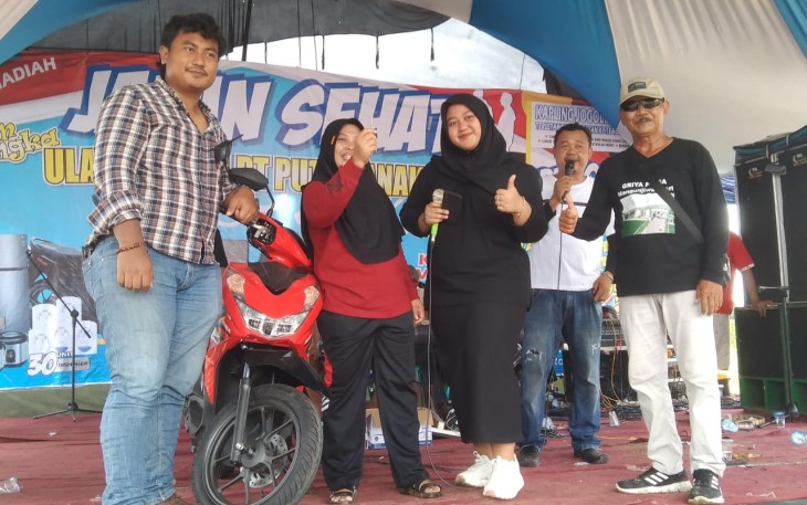 Maulana Rohman Sidiq saat menyerahkan hadiah kejutan utama berupa sepeda motor kepada peserta jalan sehat yang digelar dalam rangka perayaan hari lahir pengusaha muda itu.