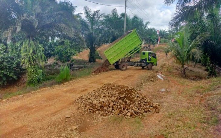 Dump Truck Tumpahkan Material Batu Pecah untuk Pengerasan Jalan dalam Kegiatan TMMD Ke-119