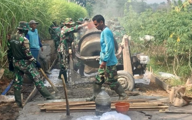 Prajurit TNI bahu-membahu dengan warga desa membangun jalan penghubung
