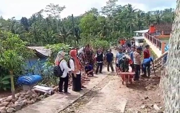 Babinsa Koramil 0801/12 Pringkuku Sertu Purnomo melaksanakan kegiatan karya bakti pembangunan rabat jalan antar desa yang berlokasi di Desa Krajan,  Kecamatan Pringkuku, Kabupaten Pacitan, Minggu (19/01/2025)