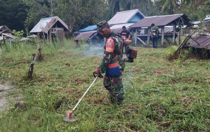 Babinsa Koramil Kokonao saat Bersihkan Area Pemakaman Umum