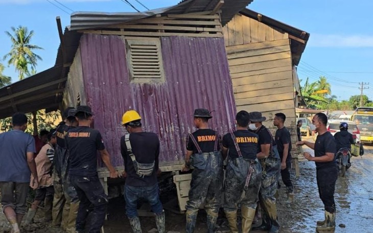 Brimob saat Pindahkan Rumah Terseret Banjir yang Melintang di Jalan Nasional Tamiang–Langsa