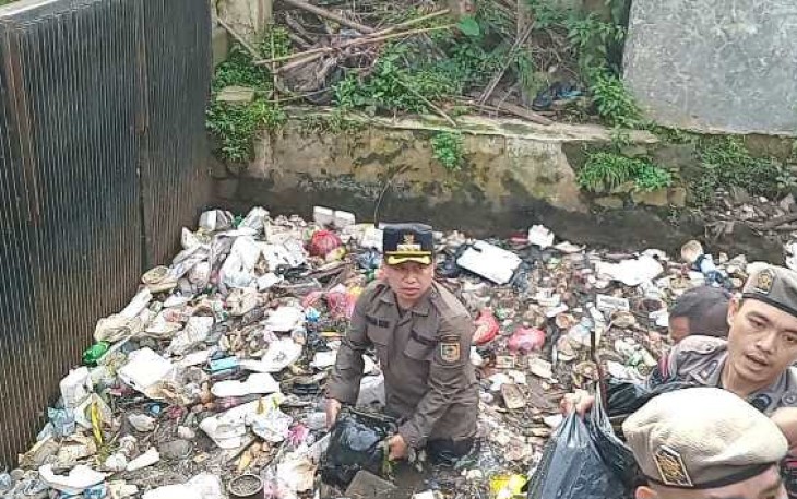Walikota Depok Supian Suri bersihkan sampah kali cabang tengah depan kantor walikota, Rabu (12/3/25)