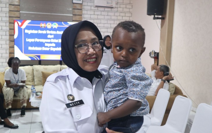 Kalapas Perempuan Jakarta Nety Saraswaty menggendong anak warga Kenya, Kamis (23/10)