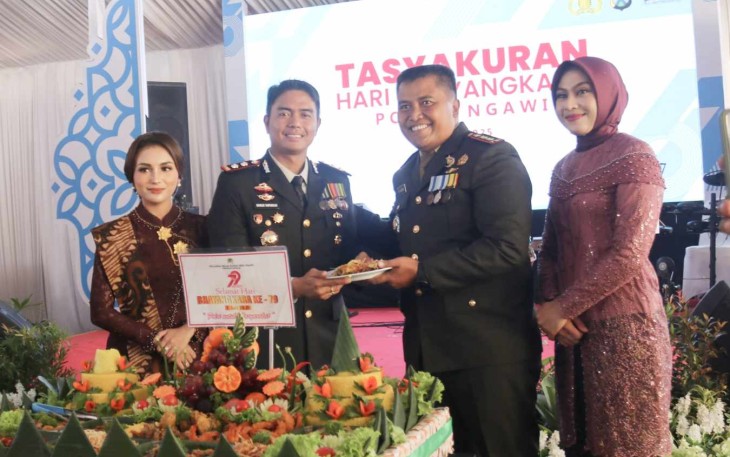Dandim 0805/Ngawi Letkol Arh Setu Wibowo (kanan) memberikan nasi tumpeng HUT Bhayangkara Ke-79 kepada Kapolres