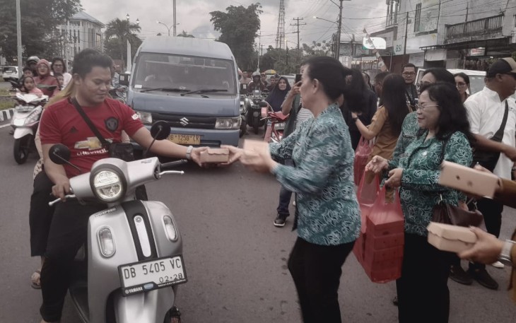 Ketua TP PKK Kota Bitung, Ny. Ellen Sondakh saat membagikan takjil kepada pengendara yang sedang menjalankan ibadah puasa