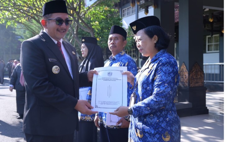 Bupati Rober Christanto menyerahkan SK kenaikan pangkat kepada salah satu ASN saat upacara Hari Kesaktian Pancasila, di halaman Kantor Bupati Karanganyar, Rabu (1/10/2025)