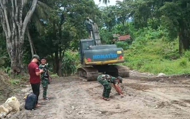 Personil Satgas TMMD dengan menggunakan excavator melakukan pemerataan dan pengerasan badan jalan program TMMD Ke-123 Kodim 1310/Bitung