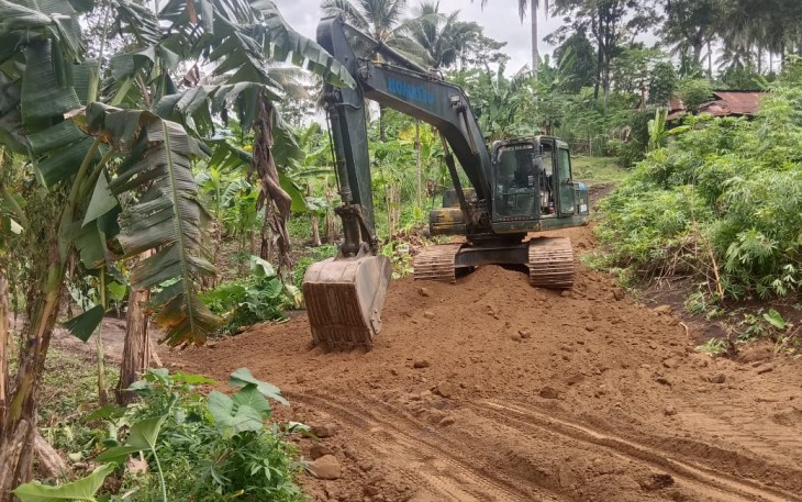 Satgas TMMD Ke-123 Kodim 1310/Bitung saat melakukan pengerasan badan jalan program TMMD dengan menggunakan excavator